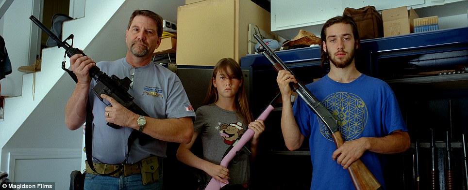 Modern family: An American family poses for a portrait holding their rifles; the young girl holds one in pale pink