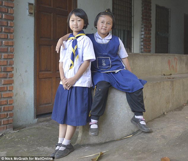 Thidaret Laojuang (left), ten and Kanlayanee Laojuang (right), seven,  are the centre of the online furore when a picture of them posing with a woman went viral after a reddit user claimed it showed them stealing a watch