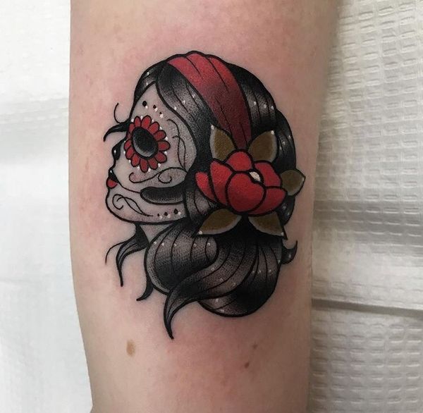 Женская татуировка черепа с красными акцентами