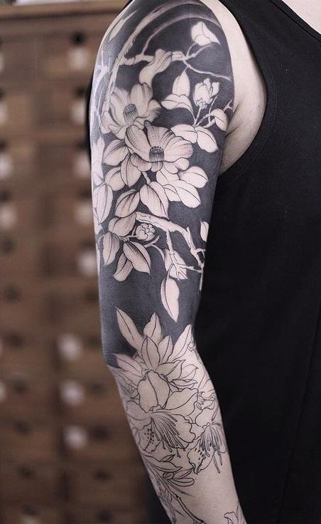 Мужское тату на руке с элементами Blackwork и цветами